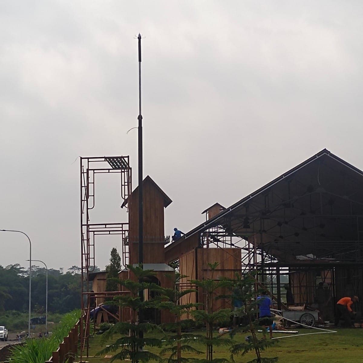 Tiang penangkal petir berdiri di samping bangunan yang sedang dibangun